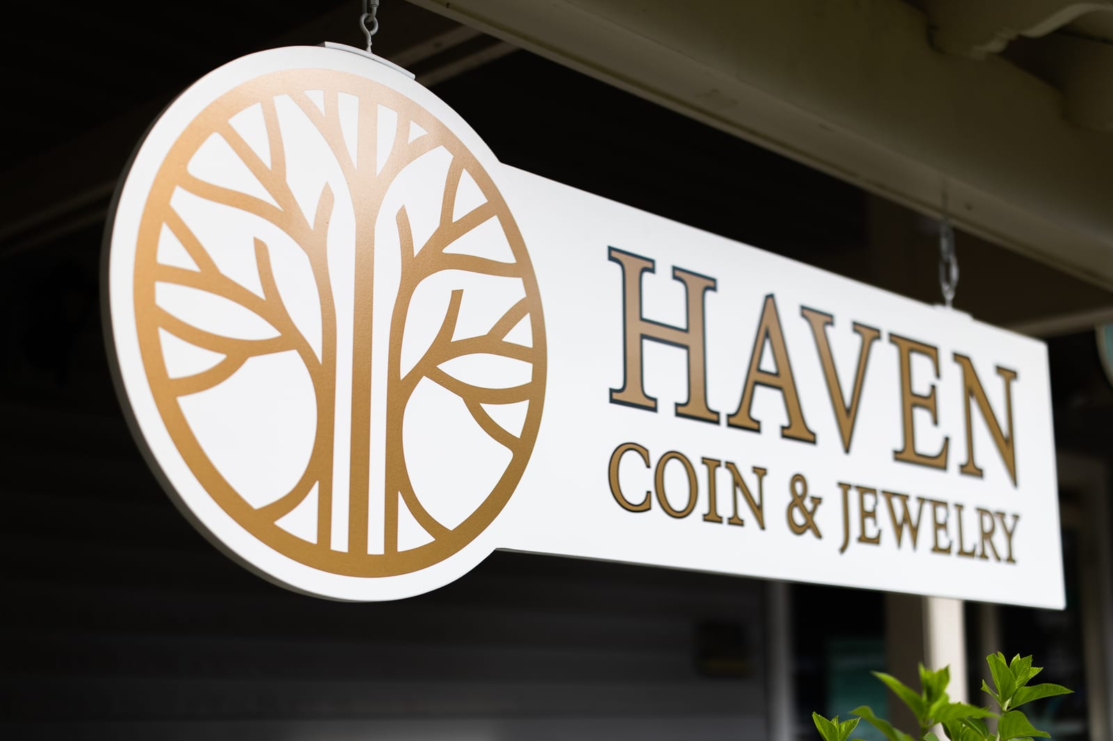 Haven Coin & Jewelry team smiling in front of the store logo