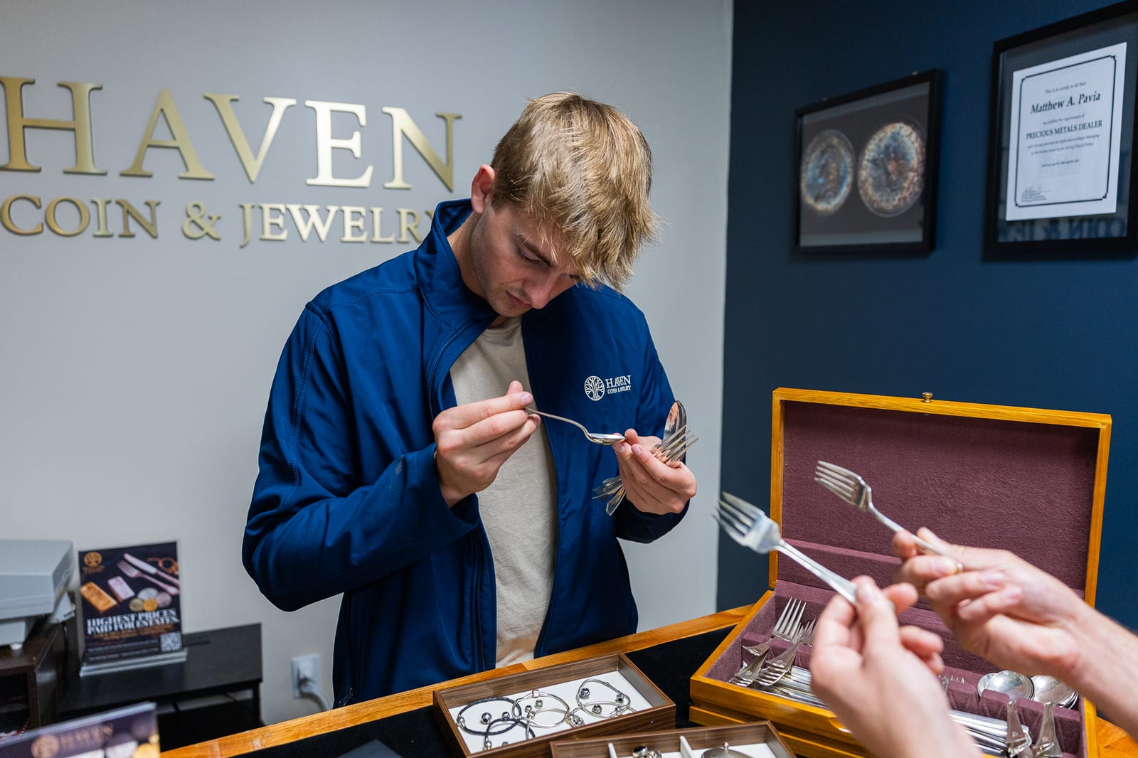 Haven Coin & Jewelry expert smiling at counter with coins and jewelry